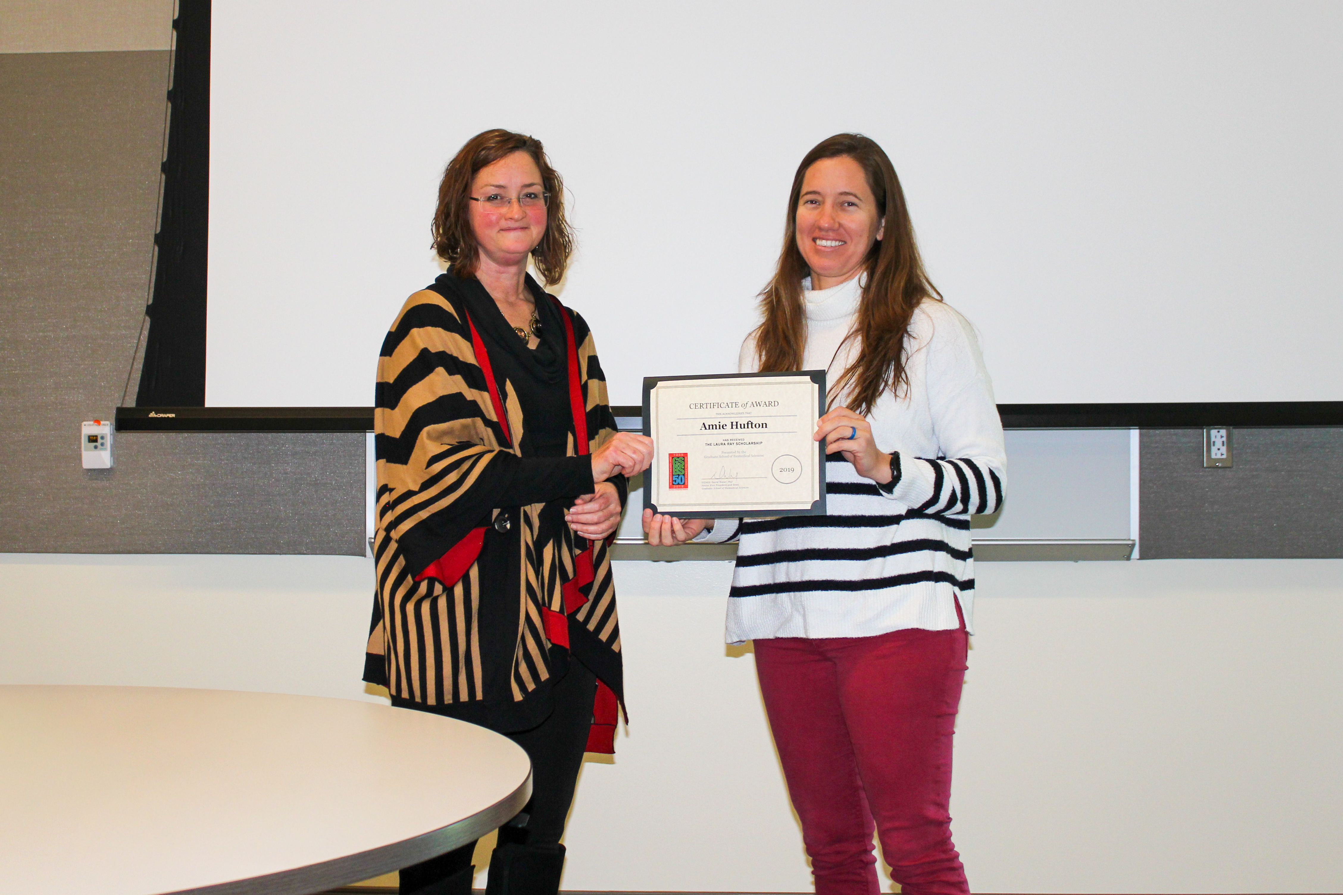 Amie Hufton receiving a certificate from Dr. Peek