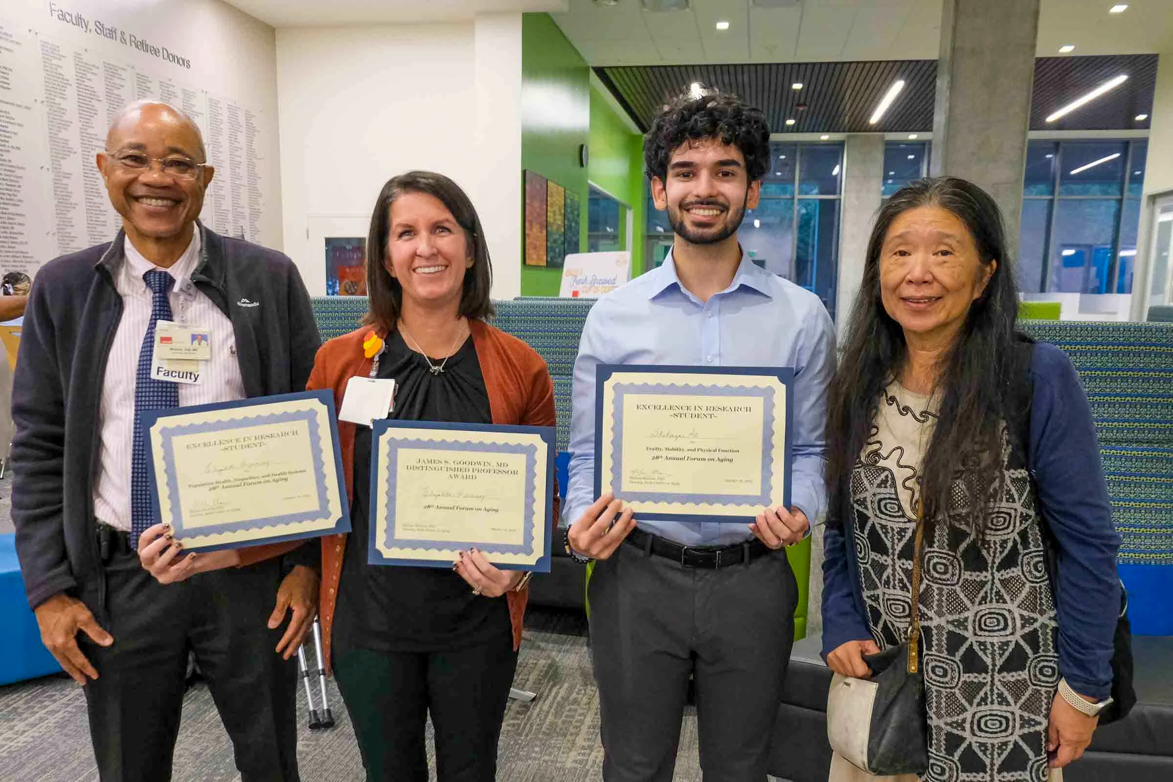 Four people stand indoors holding award certificates, including MD/MPH student Sheheryar Ali and three faculty members, smiling after recognition at the 28th Annual Forum on Aging.