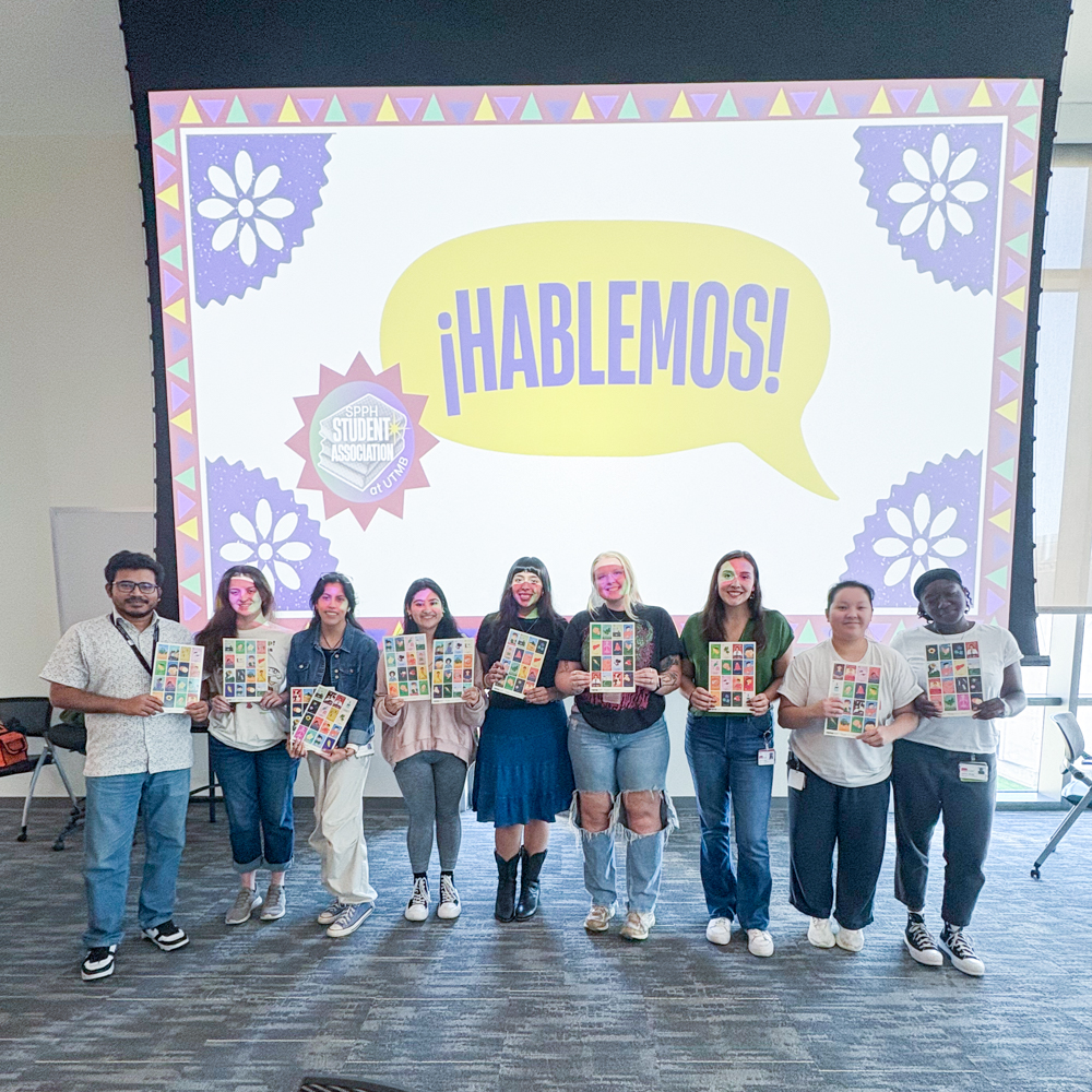 Students standing together in front of a colorful Hablemos event display backdrop