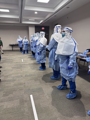 Group of healthcare workers stand in line fully dresses in PPE