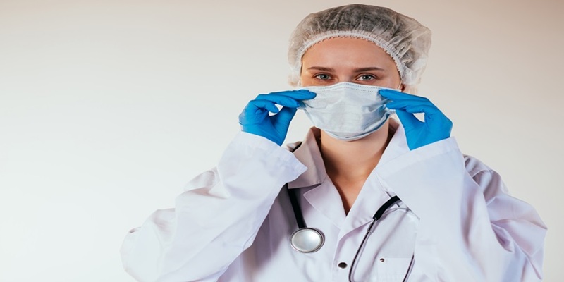 Hospital worker puts on N95 mask