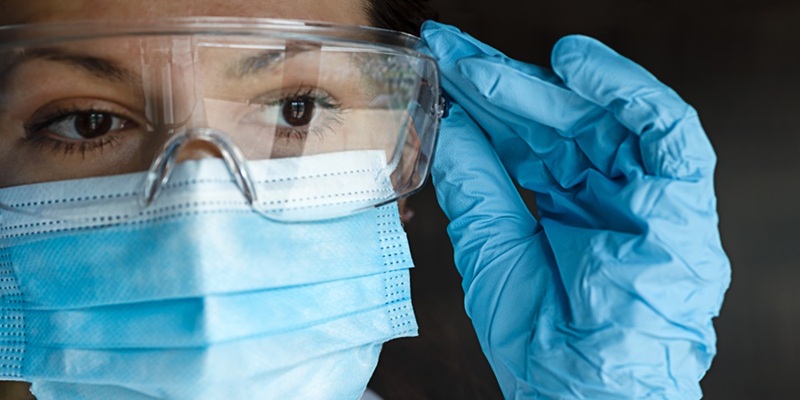 healthcare worker adjusting safety goggles