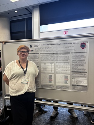 Lyudmyla poses at conference with research poster