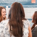 symposium attendees speak in front of posters