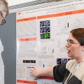poster presenter dicusses post with judge