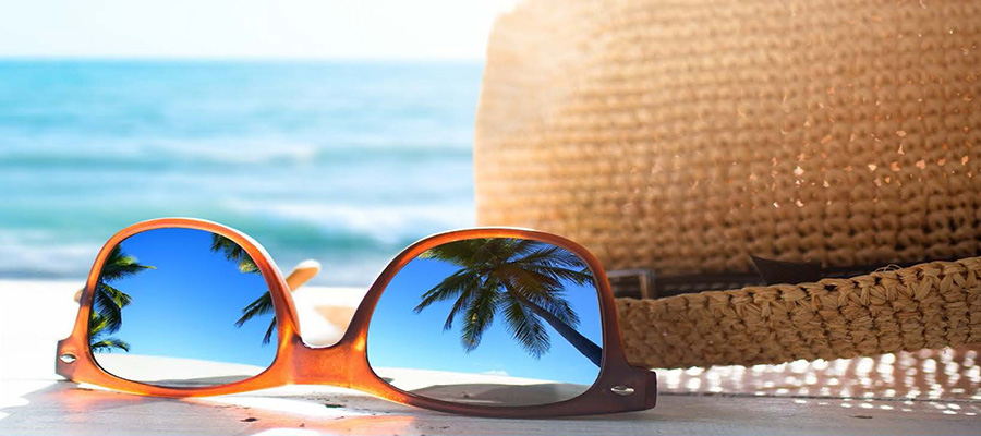 Close up of sunglasses and a hat on a beach