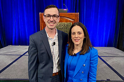 Reagan Davis and Amber High pose together in front of a podium at a recent conference