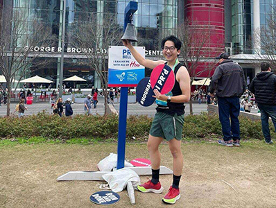 Running has become a major part of life for some participants, like Bruce Chang-Gu. Four people are seated on a small boat with a blue sky behind them.