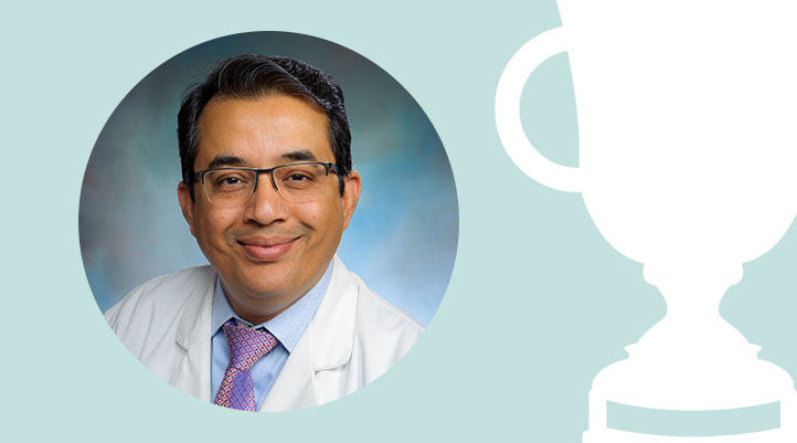 Headshot of Dr. Peeyush Bhargava on a light teal background next to a white trophy graphic