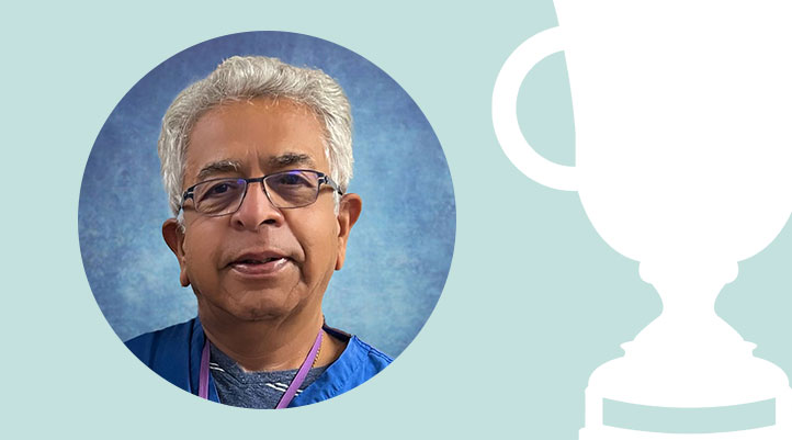 Headshot of Dr. Rakesh Vadhera against a light teal background with a white trophy graphic