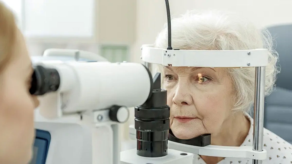 A senior woman with white hair is having an eye exam.