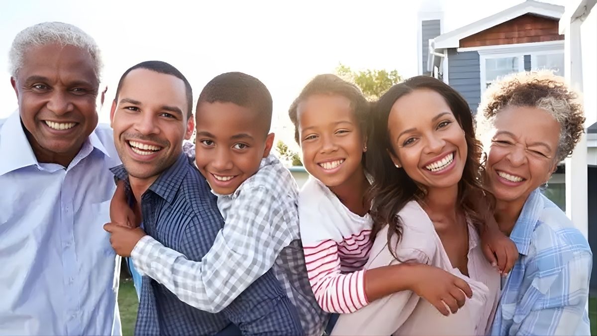 Six family members of different ages pose together in a row, smiling