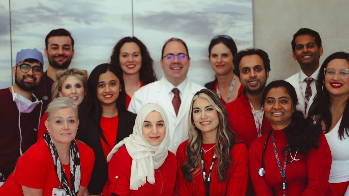 Facutly and staff from the Cardiovascular Medicine wear red in a smiling group photo