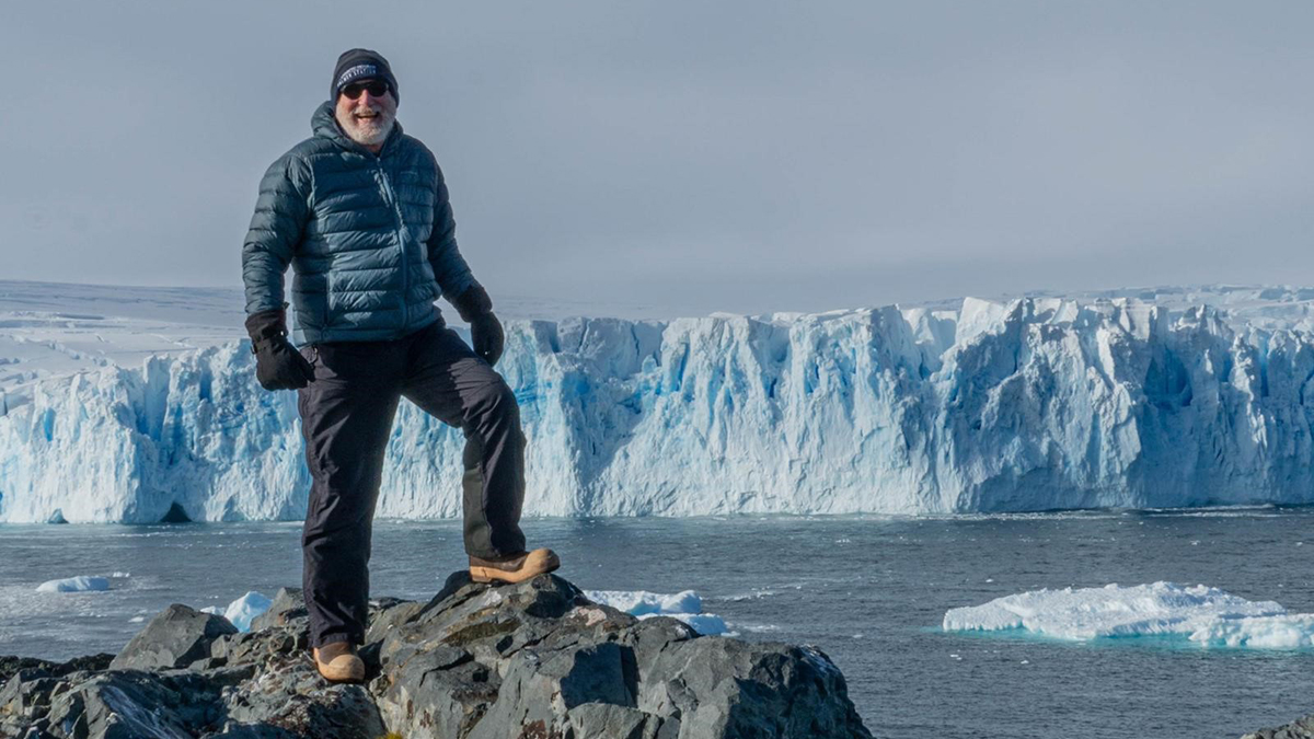 Dr. Joseph Shubert poses in front of a glacier in Antarctica