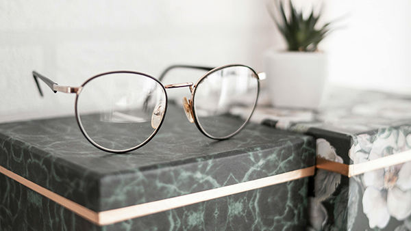 A pair of eyeglasses sitting on top of a marble box