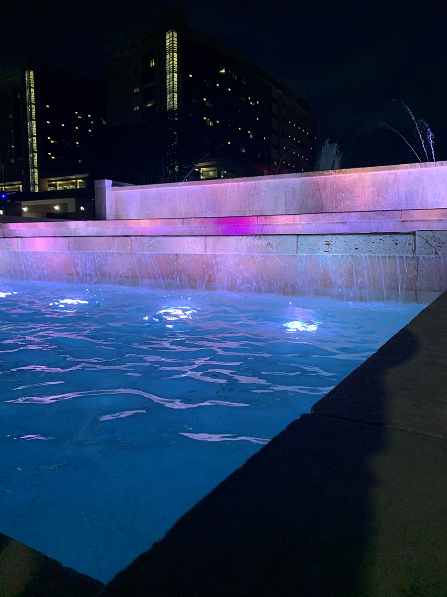 A water feature with colorful lights at night
