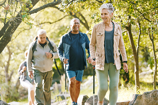 Healthy lifestyle Three middle aged individuals happily hiking in an outdoor setting.