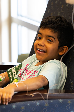 Jose getting infusion Jose happily sitting a chair receiving his gene therapy infusion