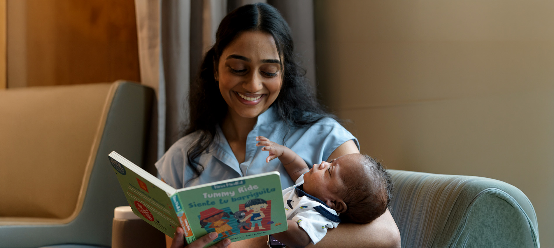 Nidhi Subramanian reads a book to a baby in the NICU