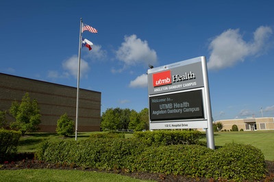 Photo outside the UTMB Angleton Danbury Campus with a digital sign and flag pole