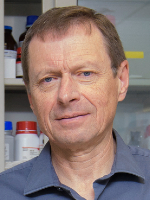 Head-and-shoulders portrait shows a man wearing a blue collared shirt 