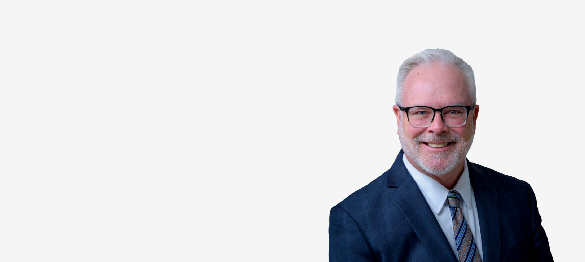 Dr. Jerry Mansfield appears in a blue suit in tie in a professional headshot.