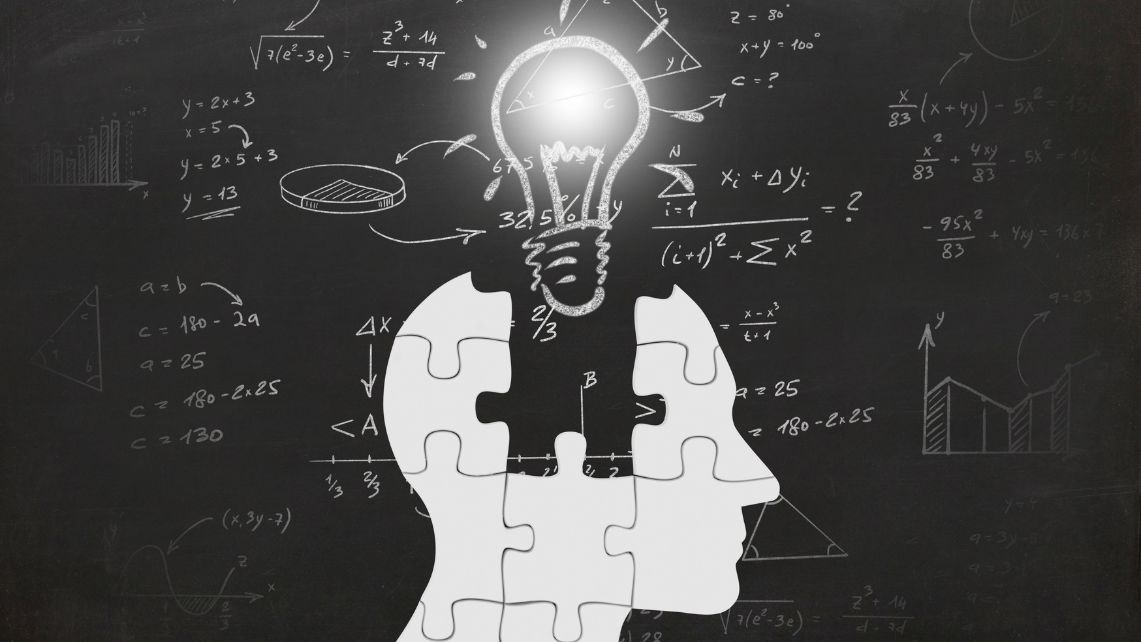 A profile of a person's face made of jigsaw puzzle pieces with a lightbulb above it and math formulas written in the background.