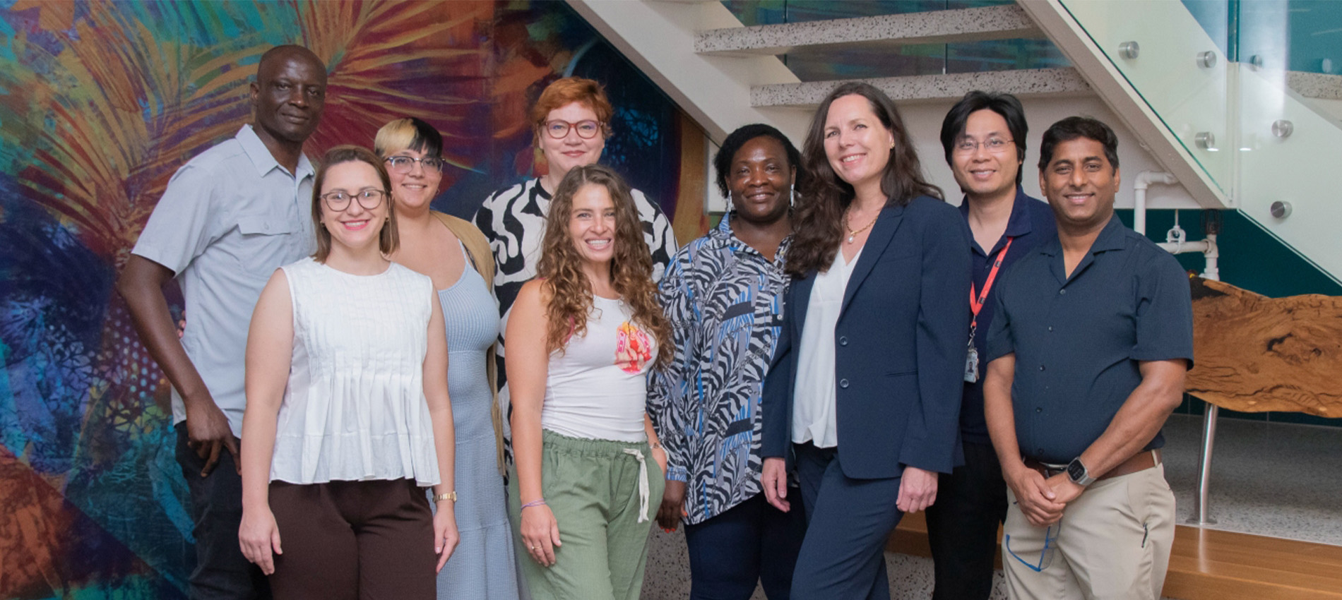 A group of UTMB postdoctoral scholars and program leaders pose inside a campus building in front of a colorful mural and staircase. The Postdoctoral Certificate Program earned national recognition for excellence in professional development.