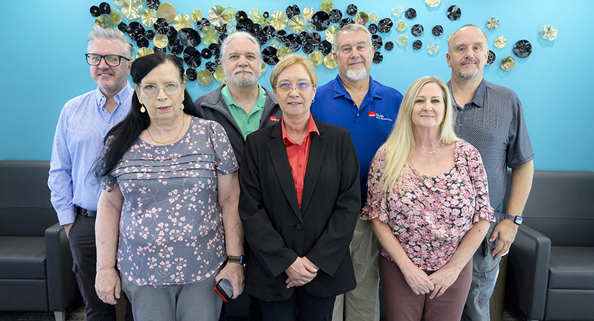 Seven staff members of the Office of Life Support Education and Training stand together in recognition of the All-Star Award they received.