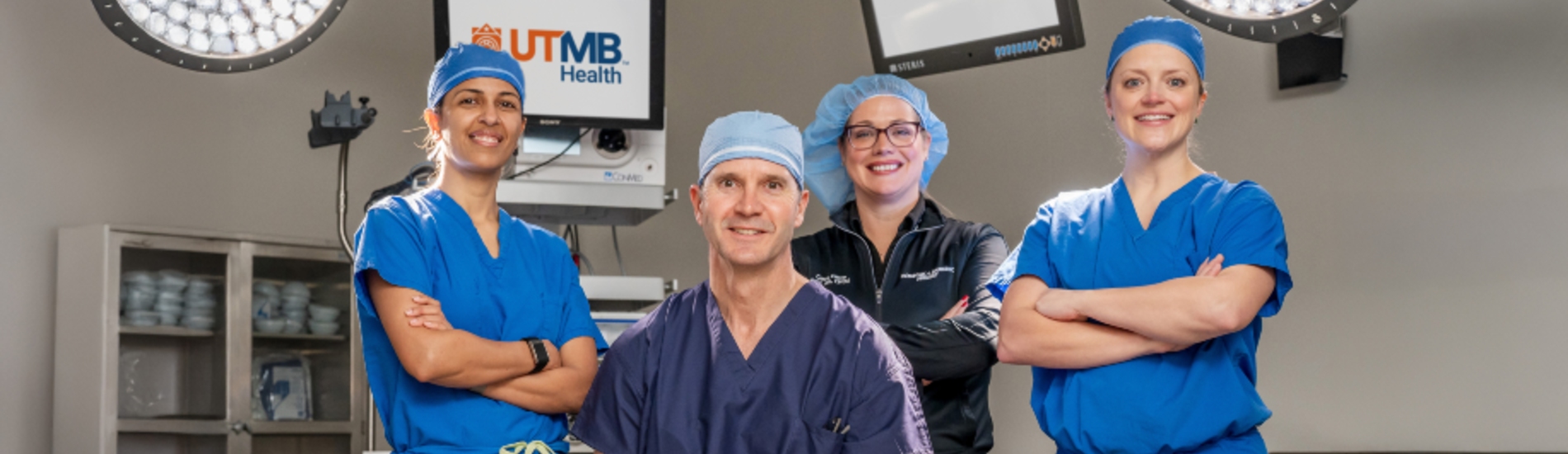 Three women and one man in blue scrubs