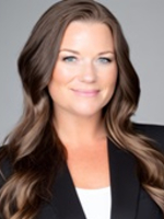 Formal headshot of woman with long dark hair wearing a white blouse and black jacket