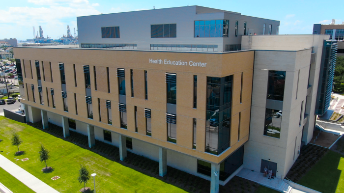 A large modern building labeled ‘Health Education Center,’ shown from an elevated exterior view with landscaped grounds.